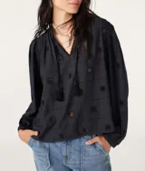 Blusa de algodón negra con bordado en relieve y detalles de borlas.