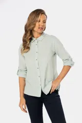 Camisa de lino color verde agua, de manga larga con botones para sujetar las mangas arremangadas.