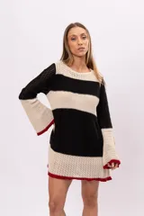 Vestido corto tejido a crochet con rayas horizontales negras y beige, mangas largas acampanadas y terminación con borde rojo. Incluye forro interior desmontable.