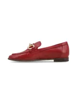 Mocasín de cuero color rojo con detalle de hebilla dorada.