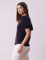 Remera blanca de modal con cuello redondo y mangas cortas abullonadas con puño.