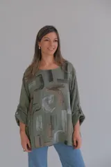 Blusa verde militar con estampado abstracto en tonos marrones, grises y negros. Tiene mangas 3/4 con botón y cuello redondo.