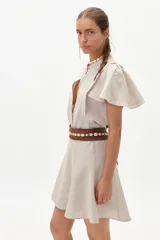 Camisa color natural de lino 100%, con cuello mao, corte holgado, botones de nácar y mangas cortas con vuelo en los hombros.