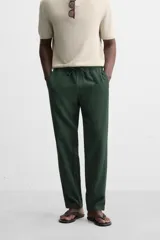 Pantalón largo verde oscuro de algodón con textura, corte recto y cintura elástica ajustable con cordón.