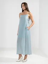 Vestido largo celeste de breteles finos, escote recto y lazos ajustables en los costados.