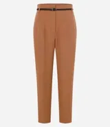 Pantalón de vestir azul marino, de corte zanahoria, con cinturón fino negro con hebilla dorada.