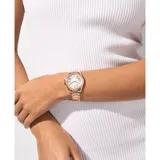 Reloj Michael Kors modelo Kacie, con caja y pulsera de acero inoxidable color oro rosa. Bisel con cristales incrustados, esfera plateada con números romanos y movimiento de cuarzo de tres agujas.