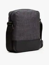 Bandolera Tommy Hilfiger modelo TH Melange Mini Reporter, color gris oscuro con detalles en negro. Presenta una franja horizontal con el logo de la marca y el detalle de la bandera en la parte inferior.