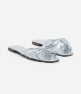 Sandalia plana mule metalizada con puntera cuadrada y tiras cruzadas con efecto crepitante.