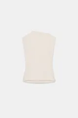Top de algodón color beige, con cuello recto, mangas asimétricas y detalle de tejido drapeado en el lateral.