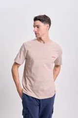 Remera color crudo de corte clásico con estampa en la espalda que incluye un tigre, la palabra 'Fierce' y la frase 'Presence in the wilderness looms large'.