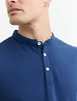 Remera manga corta con cuello mao y media botonadura, color azul.