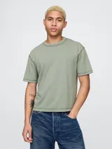 Remera verde oliva de corte cropped, con cuello redondo y mangas cortas.