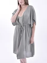 Vestido corto color gris claro, con escote en V, mangas cortas amplias y lazo ajustable en la cintura.
