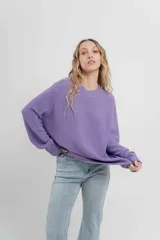 Sweater azul de punto medio, amplio, suave, con escote a la base y puños en mangas y en acabado inferior.