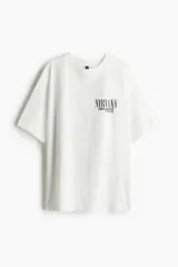 Remera blanca de corte amplio con cuello redondo y mangas cortas. Estampado frontal con el logo de Nirvana y la leyenda "Unplugged in New York".