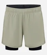 Bermuda deportiva color verde claro con short de compresión interno negro, cintura elástica con cordón ajustable y detalle reflectante trasero.