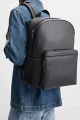 Mochila negra con textura grabada, compartimento principal con cierre de cremallera, compartimento acolchado interior para dispositivos electrónicos de hasta 13 pulgadas, bolsillo frontal con cierre de cremallera, dos bolsillos laterales planos, asa de mano y dos asas de hombro ajustables.