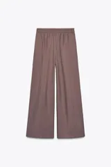 Pantalón palazzo color marrón topo, de tejido fluido, tiro medio, cintura elástica, bolsillos laterales y pinzas frontales.