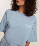 Remera corta celeste de algodón con estampado en la espalda con texto en blanco.