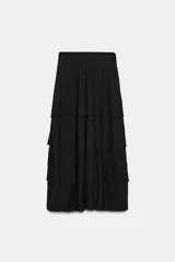 Falda larga negra de tiro alto con volantes en el mismo tejido.