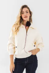 Chaqueta de punto negra con cuello clásico, cierre frontal con cremallera, mangas 3/4 con puños fruncidos, bolsillos laterales con botón y corte holgado.