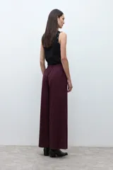 Pantalón de mujer color beige, tiro alto, con pliegues (pinzas) frontales y corte ancho y recto en las piernas.