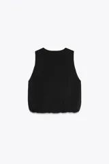 Top negro de punto con cuello redondo y sisa. El bajo es abullonado con elástico interior.