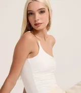 Body blanco de jersey con escote asimétrico y un solo bretel fino decorado.