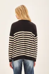 Sweater de punto a rayas horizontales en blanco y negro, con detalle de corazón rojo en el pecho.