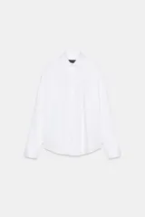 Camisa oversize blanca de popelina de algodón, con cuello solapa, manga larga con puños y cierre frontal con botones.