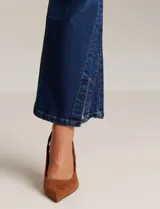 Jean elastizado azul oscuro, marca Mynt 1792, de tiro alto y corte bootcut con tajos laterales en el ruedo. Cuenta con pretina con pasadores, botón y cierre, y bolsillos delanteros y traseros.