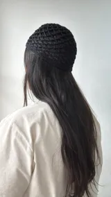 Gorro negro de tejido crochet con patrón de red.