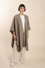 Ruana marrón con diseño a cuadros blancos, terminación envivada y flecos cortos.