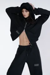 Campera negra con cierre frontal, capucha y logo de la marca en el pecho.