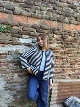 Chaqueta tejida en lana merino azul y crudo a rayas horizontales, con cuello redondo y ribete azul en cuello, puños y ruedo.