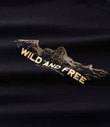 Remera de manga corta y cuello redondo color verde militar, corte comfort, con un pequeño estampado frontal que incluye un diseño de montañas y el texto "WILD AND FREE".