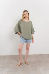 Blusa verde oliva de lino, de corte holgado, mangas 3/4 y cuello redondo.