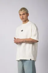 Remera negra de corte oversize con cuello redondo y mangas cortas. Estampado pequeño en el frente y parche estampado en la espalda.