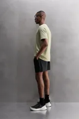Camiseta deportiva verde militar confeccionada en tejido estructurado, ligero y elástico. Tiene cuello redondo, manga corta y bajo con aberturas laterales. Incluye logo estampado en el bajo.