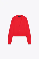 Chaqueta de punto roja con escote pico y manga larga. Tiene vivos laterales combinados a contraste y cierre frontal con botones forrados a tono.