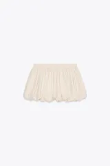 Falda pantalón corta color crudo, de tiro medio, con cintura elastizada y detalle de tejido con volumen y pliegues.