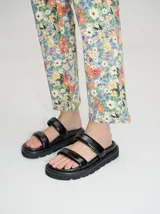 Sandalias blancas con doble tira ancha y plataforma negra.