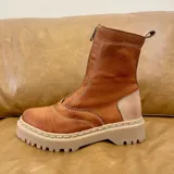 Bota de cuero color terracota con cierre frontal y suela track color beige.
