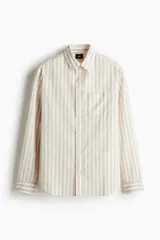Camisa de manga larga con cuello inglés y bolsillo en el pecho. Diseño a rayas verticales en tonos beige y blanco. Corte estándar.