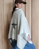 Ruana color beige con borde marrón y una estrella gris estampada en la espalda. Tejida en algodón.