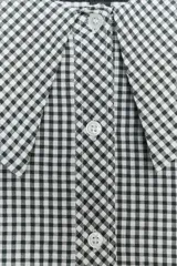 Camisa de manga larga con puños elásticos y cuello bobo con volantes. Cierre frontal con botones.