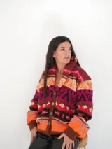 Saco de lana con estampado geométrico multicolor, con base topo y detalles en verde.