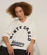 Remera blanca de corte amplio con cuello en V y mangas cortas. Estampado frontal con la frase "Monte Carlo Monaco" en letras azul marino.
