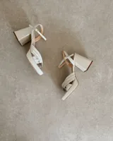 Sandalia de cuero vacuno color dorado, con plataforma y taco cuadrado. Presenta una tira delgada en el tobillo y detalle de nudo en la capellada.